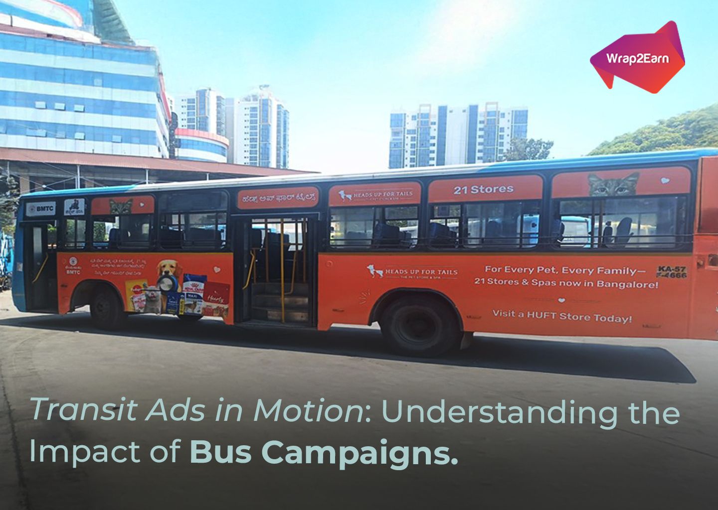 A city bus wrapped with colorful advertising from Wrap2Earn, moving through a busy urban street.